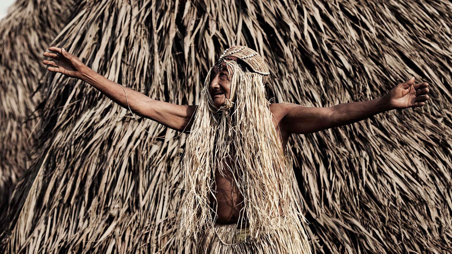 Homem dança na aldeia Yawanawá, no lançamento do projeto de habitação de autoria do escritório de arquitetura Rosenbaum
